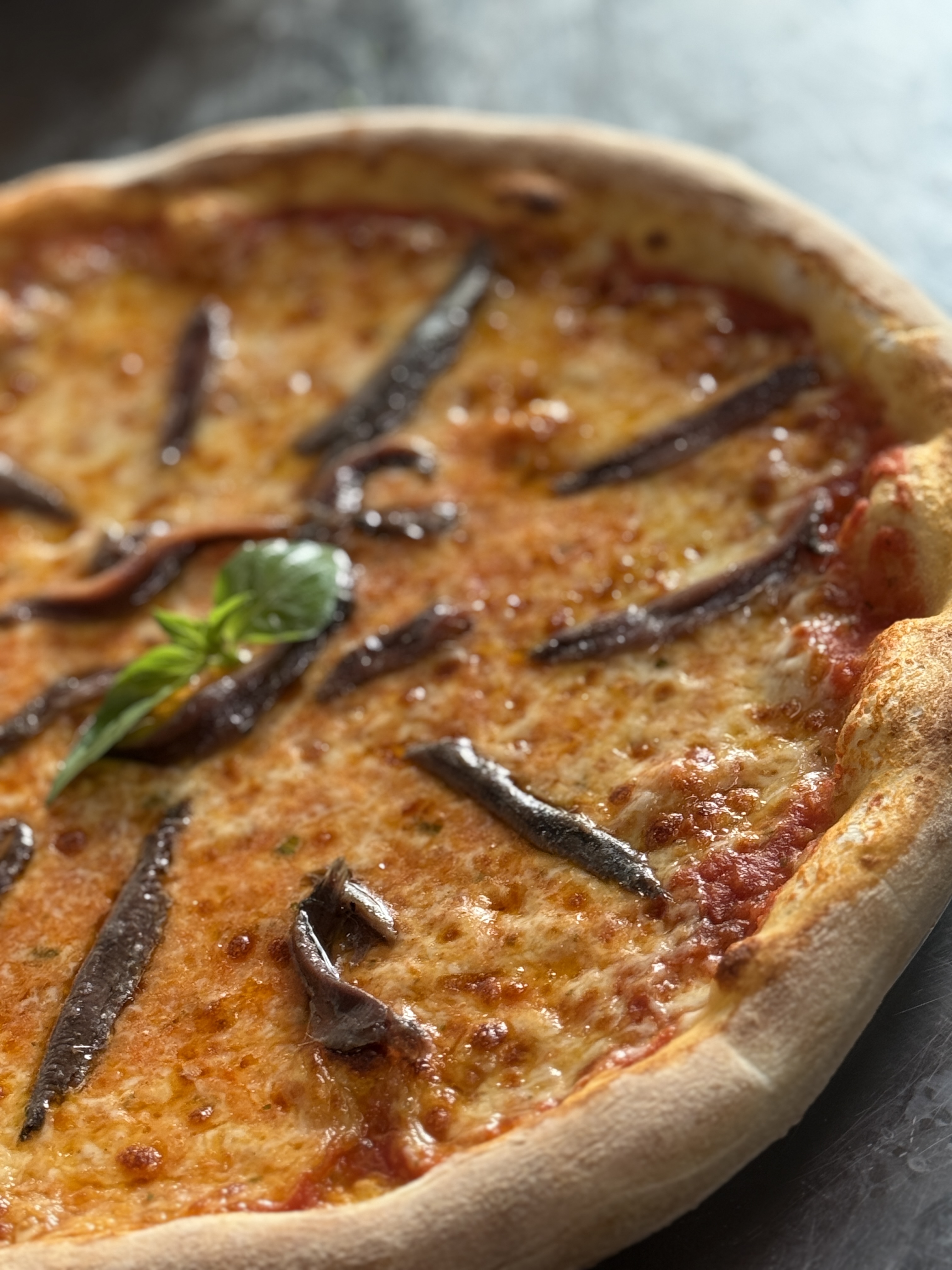 Pizza Napoli mit Sardellen und frischem Basilikum