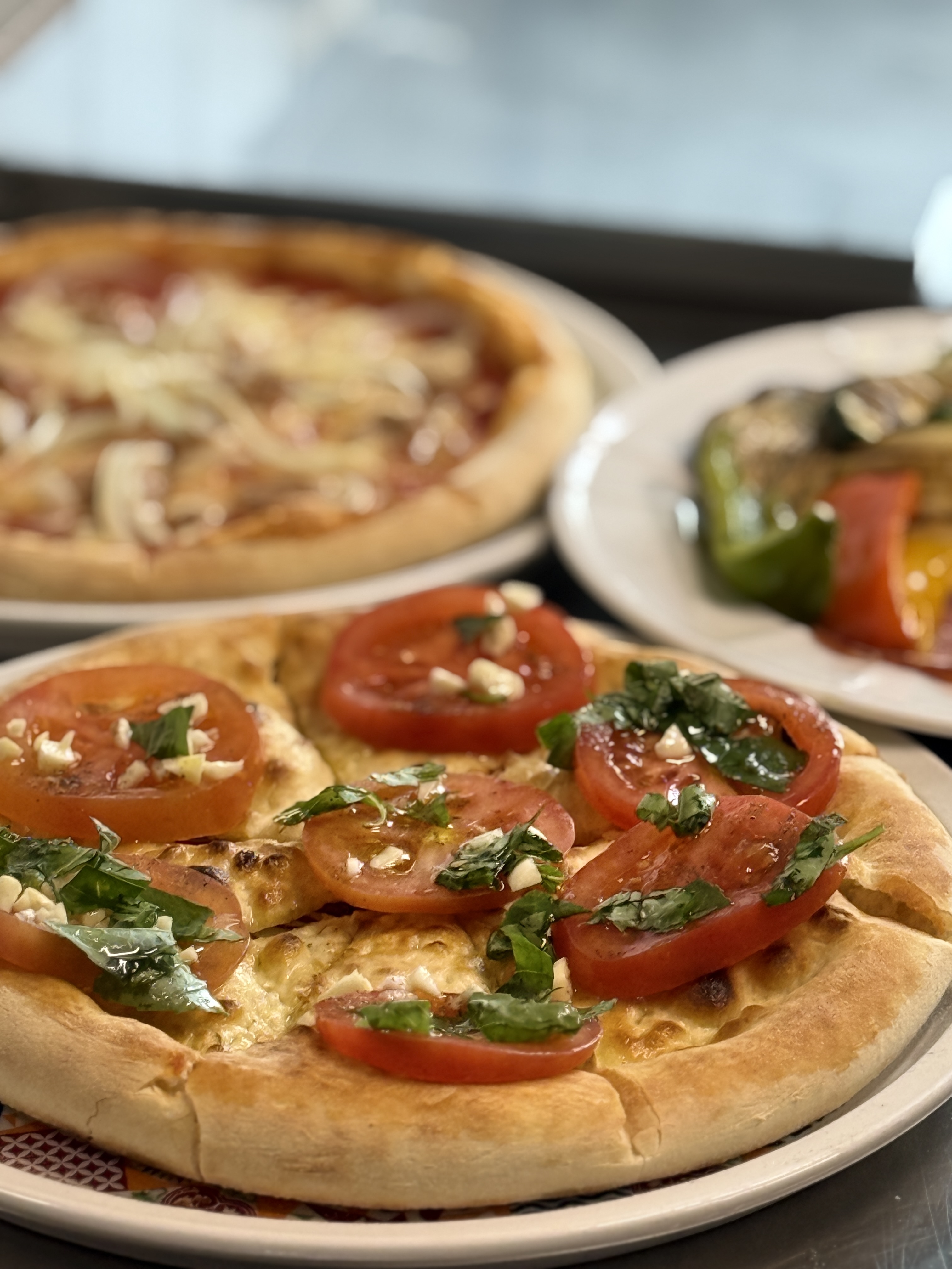 Pizza mit frischen Tomaten, Knoblauch und Basilikum aus unserer Küche
